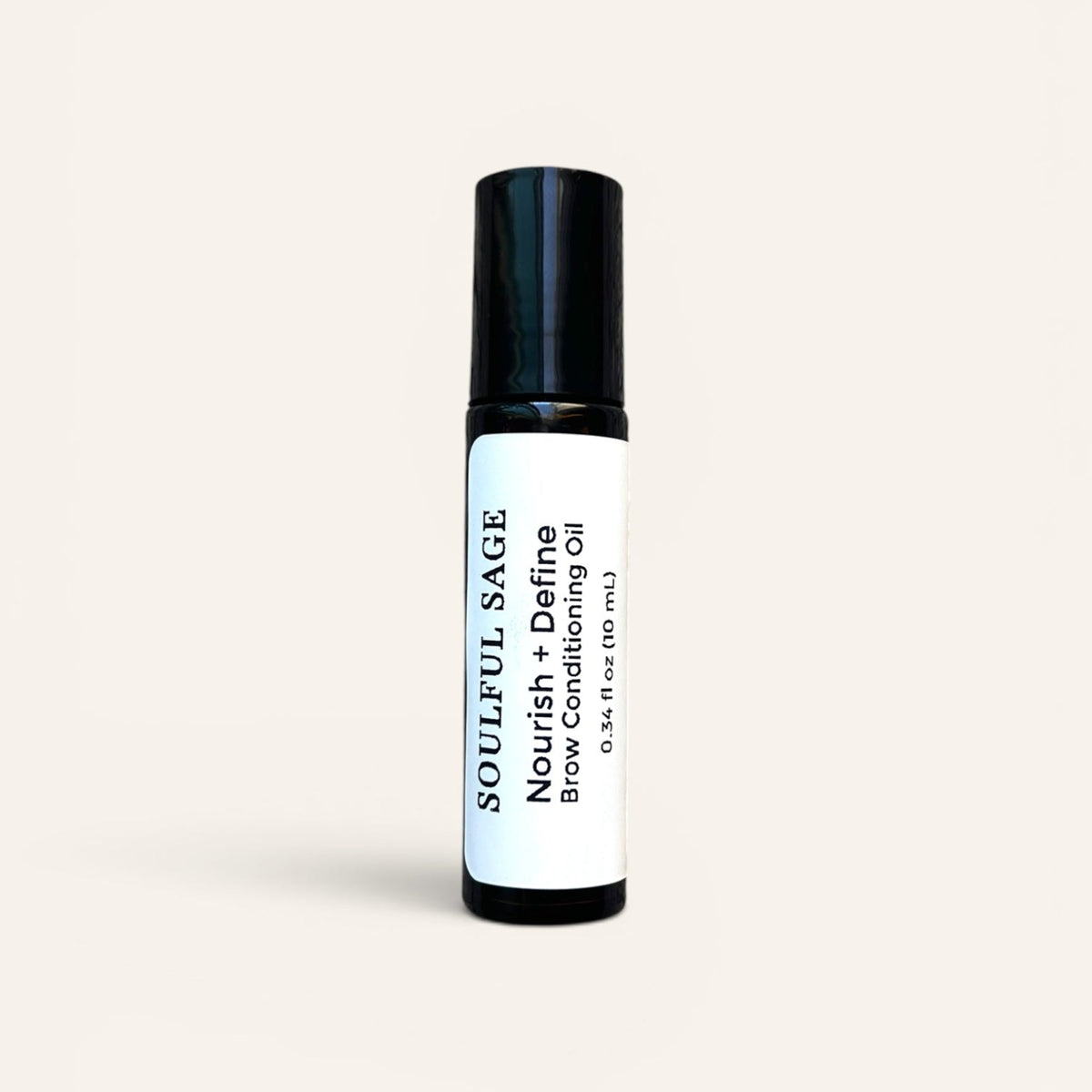 Soulful Sage Nourish + Define Brow Conditioning Oil roller bottle with a white label and black cap, shown on a soft neutral background.