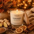Golden Hearth soy candle by Soulful Sage glowing beside fresh ginger, dried orange, cinnamon, clove, star anise, and seasonal autumn greenery