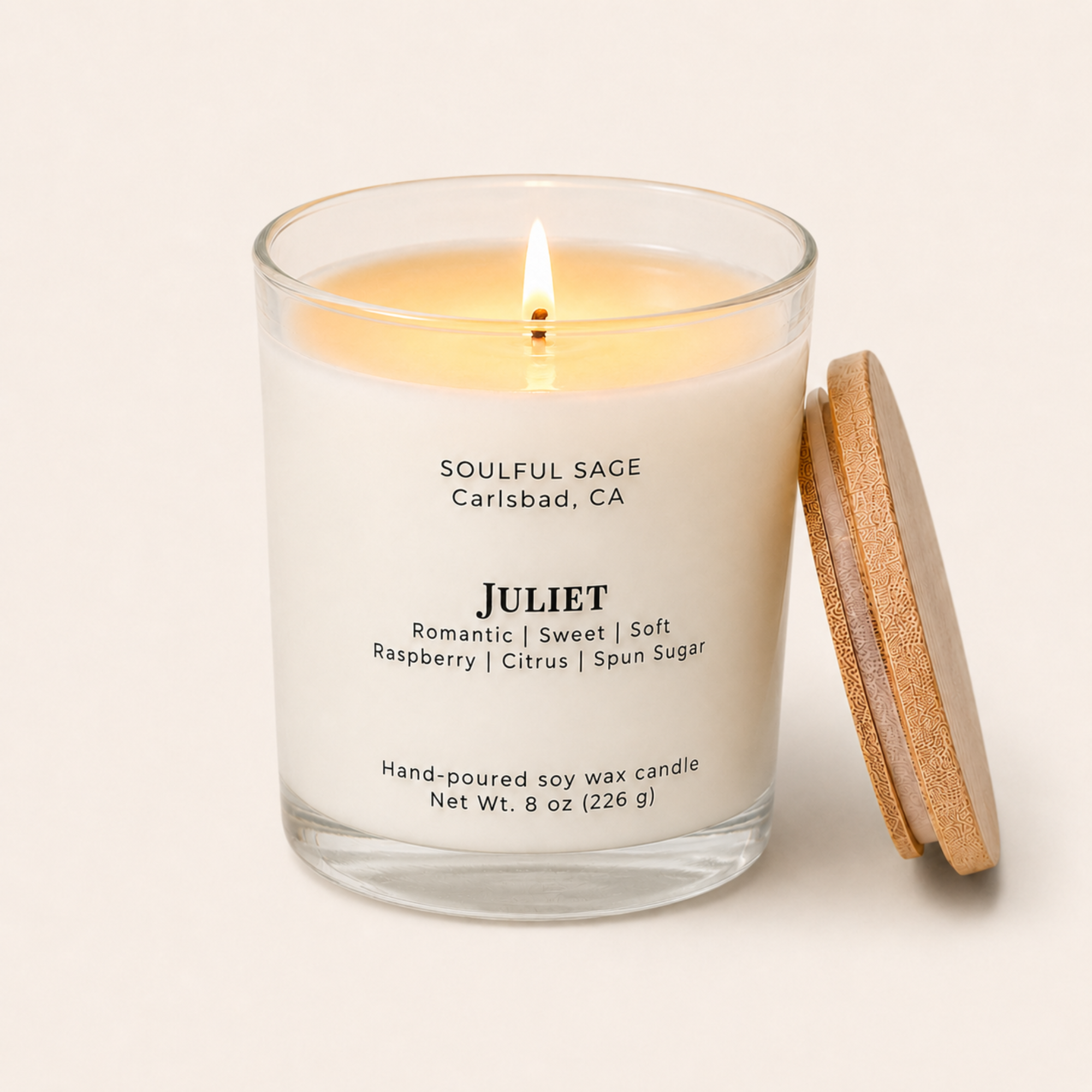 Lit Juliet soy candle by Soulful Sage with bamboo lid leaning on the side, full melt pool, and notes of raspberry, citrus, and spun sugar.