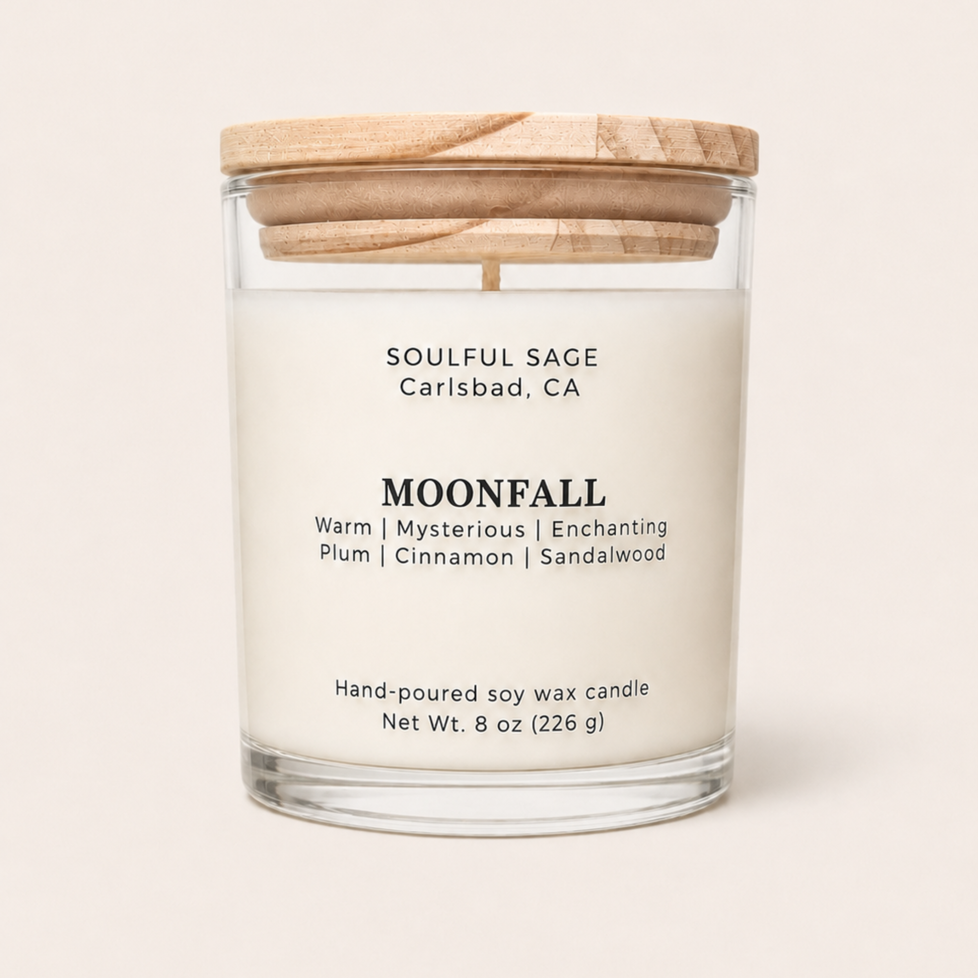 Moonfall soy candle by Soulful Sage with plum, cinnamon, and sandalwood notes in a clear glass jar with a natural wood lid.