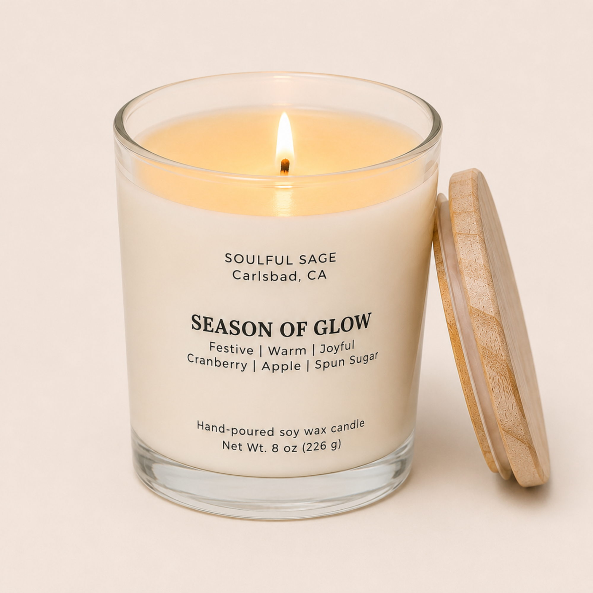 Season of Glow lit soy candle by Soulful Sage with bamboo lid leaning on the side, full melt pool, and notes of cranberry, apple, and spun sugar.